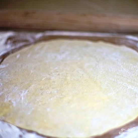 Спустя 20 минут разрезаем тесто на несколько частей, каждую раскатываем в тонкий пласт.