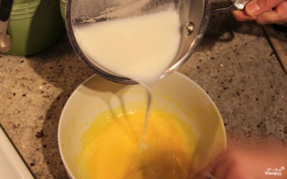 Помешивайте молоко, чтобы сахар растворился, потом добавьте его в желтки, вливая струйкой и помешивая при этом. 