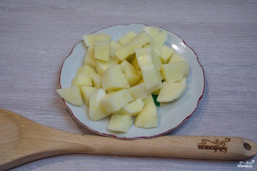 Нарежьте картофель кубиками, добавьте его к курице в кастрюлю. 