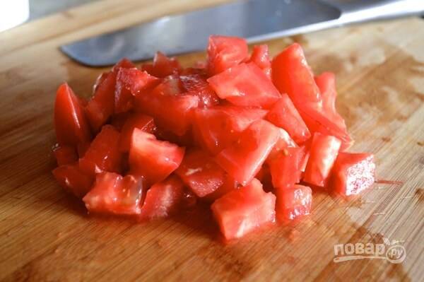 4. Добавьте предварительно помытый и нарезанный помидор, готовьте в течение 1 минуты.