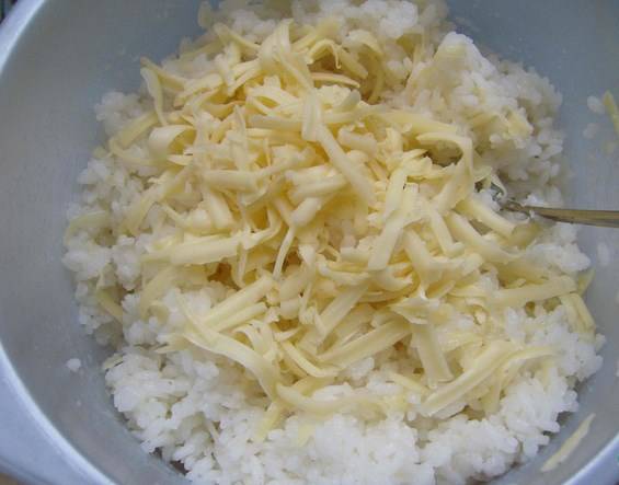 Рис смешайте с тертым сыром. Немного сыра оставьте для посыпки. 