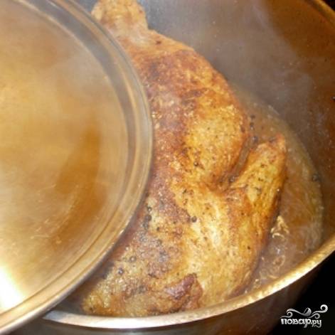 Когда чеснок зазолотится - заливаем его водой (примерно 0.5 литра). Доводим до кипения, регулируем на соль и кладем в воду нашего цыпленка. Накрываем крышкой и тушим 15 минут на среднем огне.