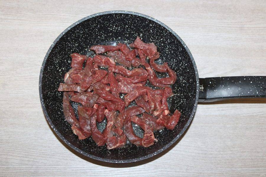 Мясо выложите на разогретую сковороду, добавьте немного растительного масла, обжаривайте на малом огне под крышкой.