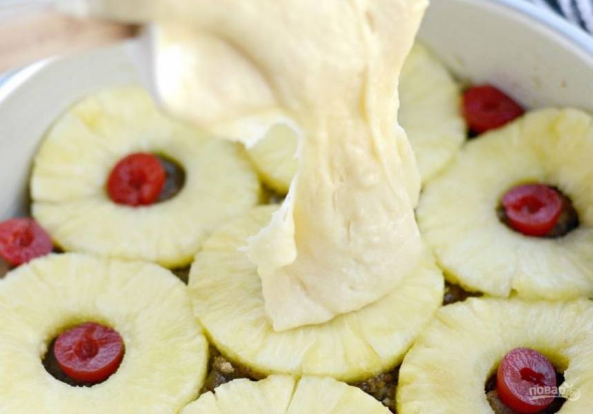 5. После этого влейте тесто на ананасы и разровняйте его.