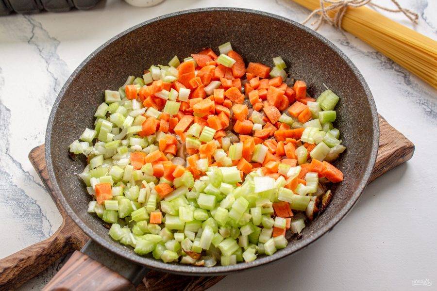Добавьте нарезанные кубиком морковь и стебель сельдерея и жарьте еще минуты 3-4 до мягкости овощей.