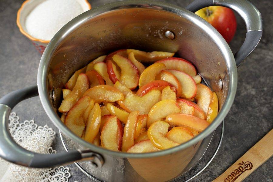 Далее поставьте кастрюлю на тихий огонь, слегка помешивайте яблоки деревянной лопаткой, сахар должен полностью раствориться и превратиться в сироп. Варите варенье после закипания минут 30. За это время все дольки станут прозрачными и слегка янтарного цвета.