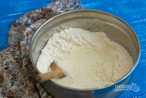 1. Для приготовления теста просейте в глубокую мисочку муку с солью. Добавьте дрожжи и влейте теплое молоко или сыворотку. 