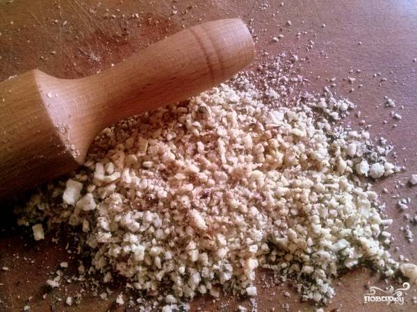 Пока тесто размораживается, подготовьте начинку: измельчить орехи с помощью скалки.