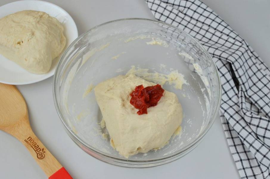 В одну часть добавьте томатную пасту, постарайтесь "вмешать" ее в тесто, также понадобится 1-2 ложки муки, потому что тесто станет липким из-за пасты.