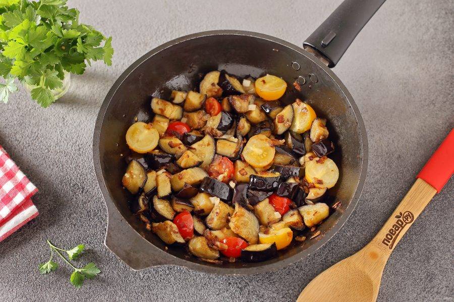 Обжарьте все помешивая до полной готовности баклажанов. За пару минут добавьте измельченный чеснок и разрезанные пополам помидоры черри.