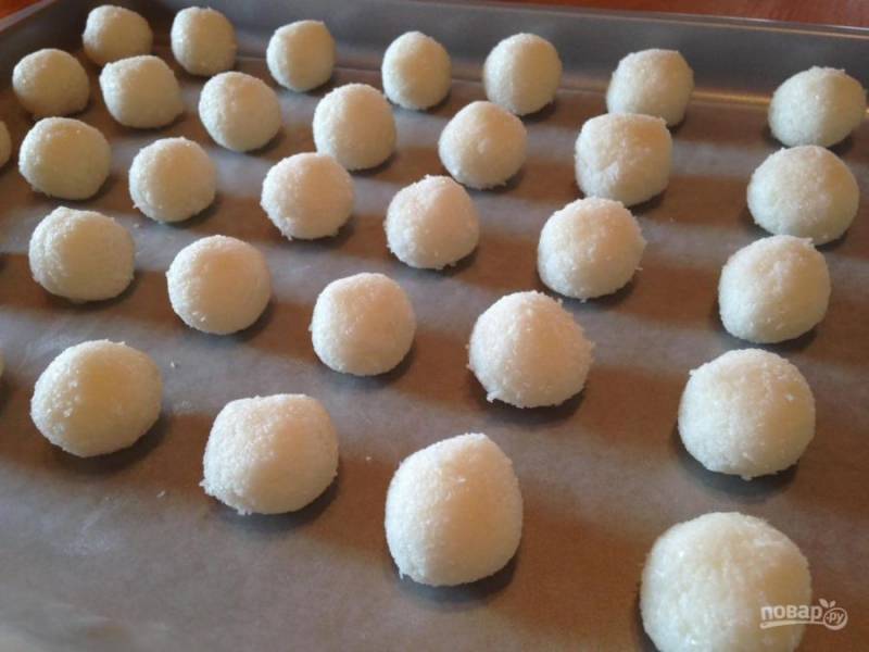 Влажными руками сформируйте небольшие шарики. Уложите их на бумагу для выпечки и отправьте в холодильник на два часа.