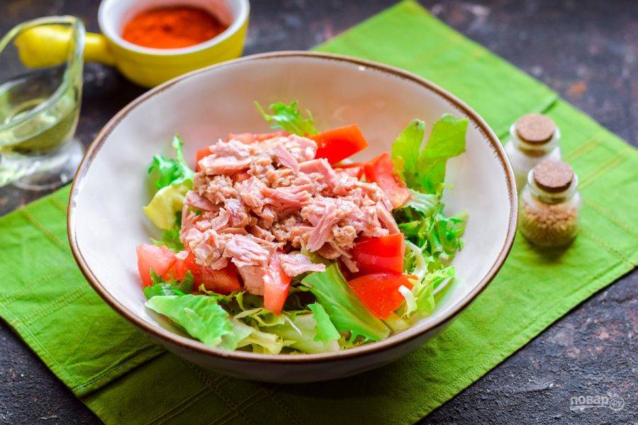 Добавьте следом в салат тунец, поломанный кусочками или размятый вилкой.