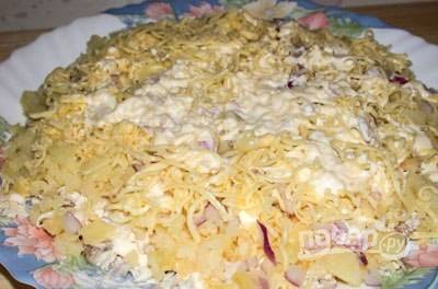 На плоскую салатницу уложите картофель. Посыпьте его луком и смажьте майонезом. Дальше — слой курицы и снова майонез. Затем натрите сыр. Смажьте его майонезом.