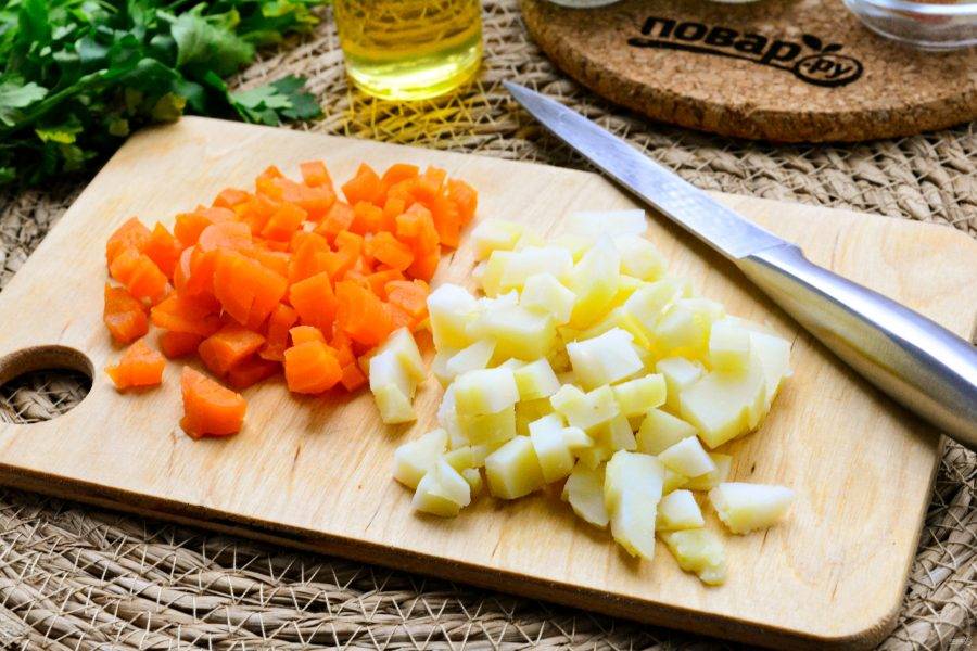 Заранее сваренные картофель и морковь нарежьте кубиками для салата.