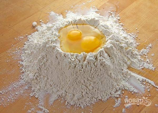 
1. Чтобы замесить тесто на манты в домашних условиях муку с солью просейте в глубокую мисочку или просто на рабочую поверхность. Сделайте в центре углубление и вбейте туда яйца.