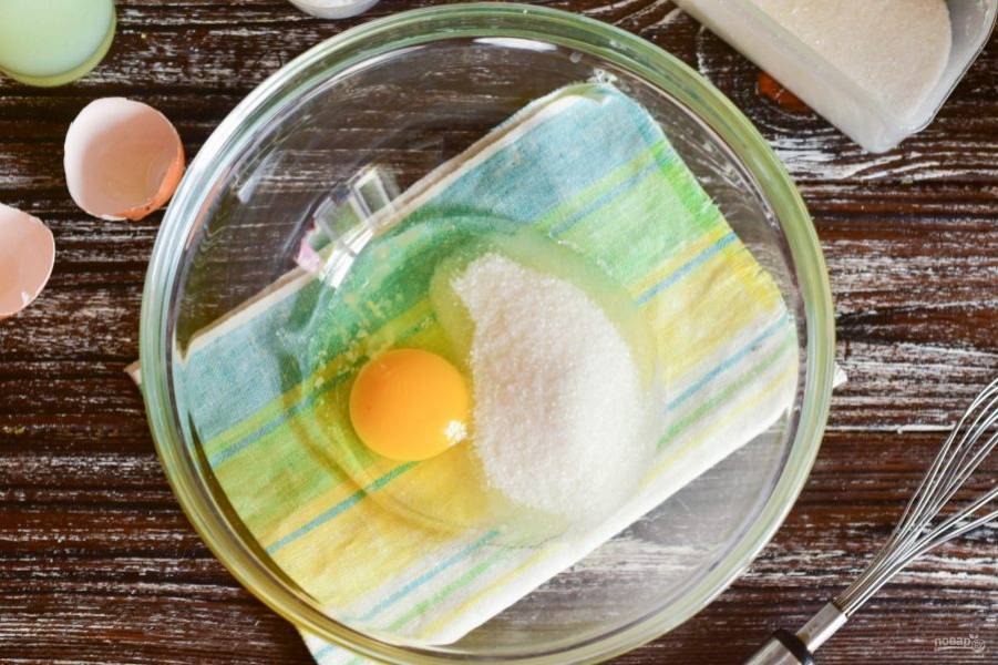 В миску вбейте куриное яйцо, добавьте соль и сахар.