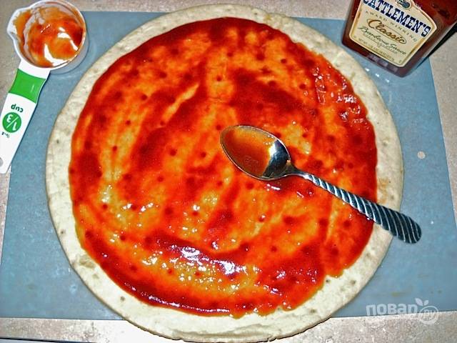 5.	Достаньте готовую основу для пиццы и смажьте ее соусом.