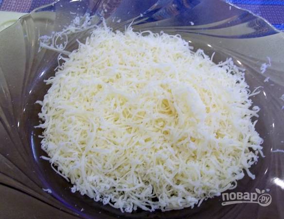 2. Сыр натрите на средней или мелкой терке и выложите в глубокий салатник. 