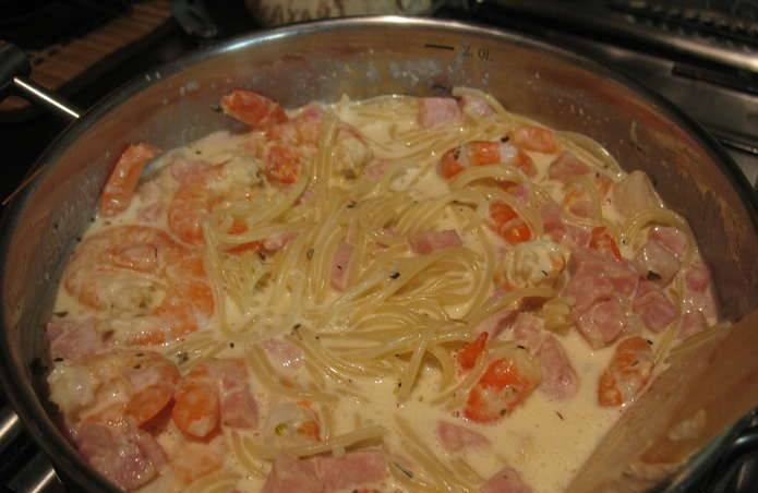 Затем добавим в соус заранее проваренные до полу-готовности спагетти. Варим еще 7-8 минут до полной готовности пасты.