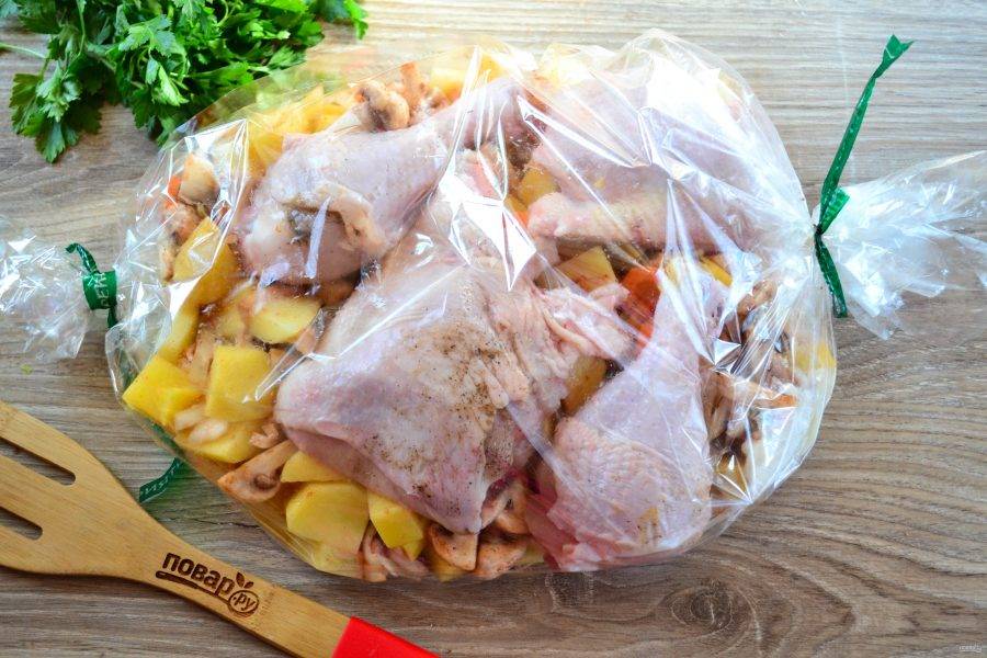 Куриные части натрите солью и перцем, выложите в рукав сверху на овощи. По желанию курочку можно предварительно замариновать в специях, майонезе или соевом соусе.