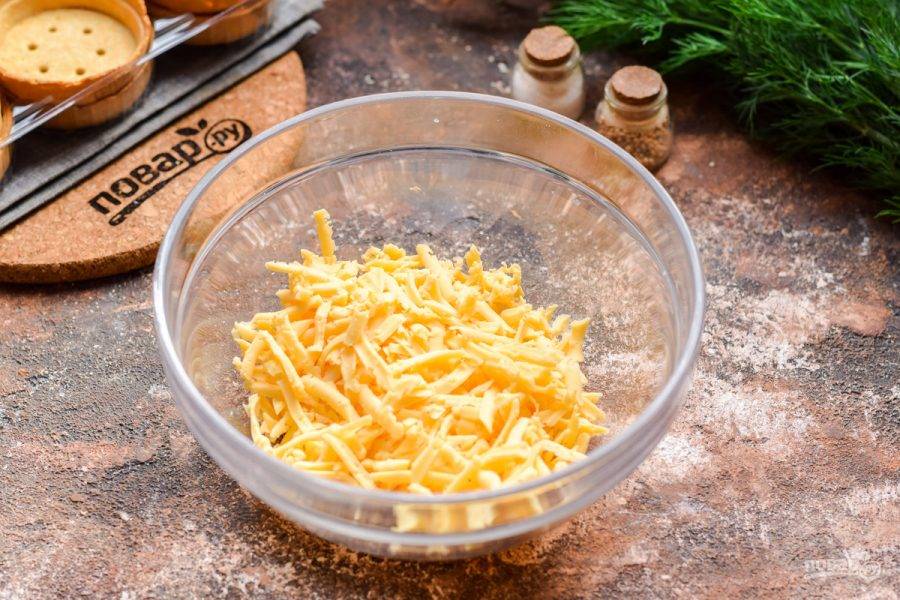 Твердый сыр натрите на средней терке, переложите в миску.