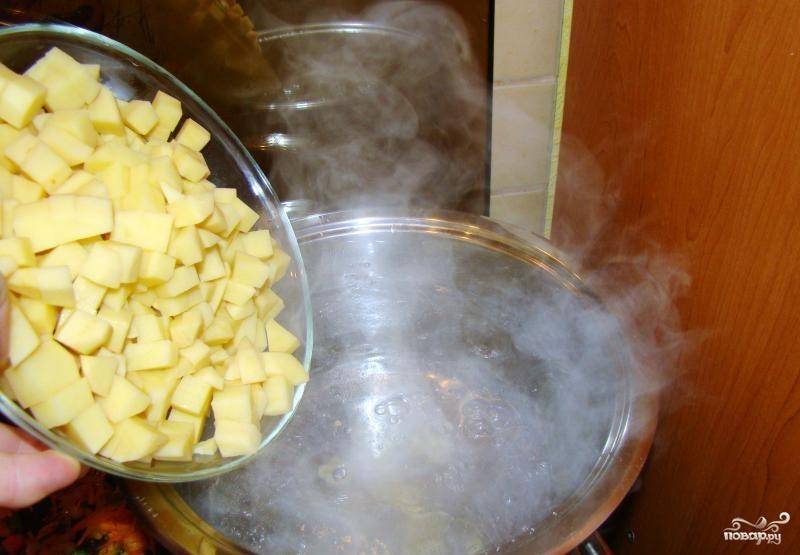 3. Доведите воду до кипения, бросьте в нее нарезанную картошку. После закипания варите ее 5 минут, затем добавьте обжаренные овощи.
