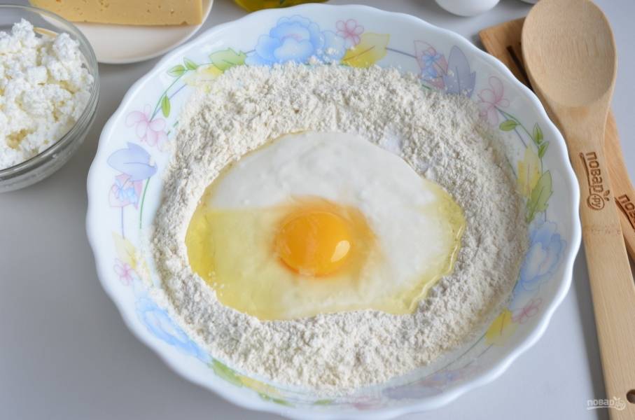 В миску просейте муку (примерно два стакана). Влейте кефир, добавьте соду, соль, яйцо. Замесите тесто. 