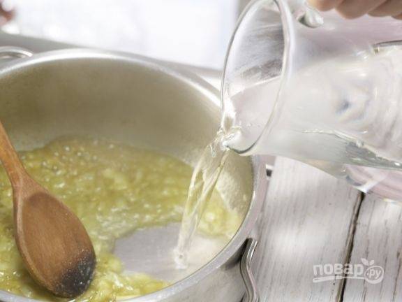 Немного обжарьте в масле лук с карри в толстой кастрюле. Затем влейте воду.