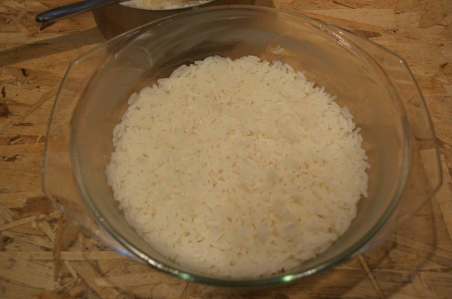 Общую массу риса разделите на  2 части. Одну часть выложите на дно формы и разровняйте.