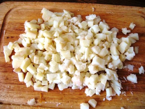 Отварите картофель, морковь и яйца до готовности. Отдельно отварите кальмаров с лимонным соком, перцем и лавровым листом в течение 2-3 минут. Нарежьте картофель. 