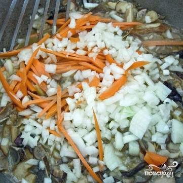 Когда грибной сок выпарится практически полностью, добавляем в кастрюлю две мелко нарезанные луковицы и одну соломкой нарезанную морковь.