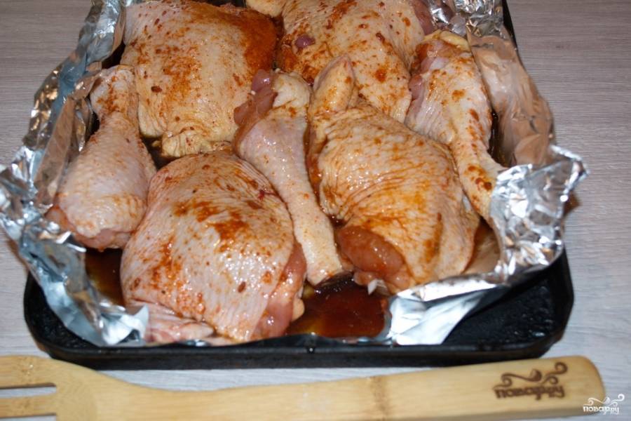 Противень застелите фольгой. Выложите на фольгу мясо шкуркой вверх. Остатки соуса вылейте на курицу. При запекании мясо вберет в себя недостающую соль и влагу. В результате получим вкусный сочный продукт с ароматной хрустящей корочкой.