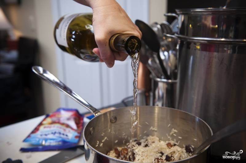 6. К рису добавьте вино и варите, пока вино полностью не впитается. Не забывайте помешивать. Затем добавьте бульон и доведите до кипения. Понизьте огонь до медленного, накройте кастрюлю крышкой и варите рис с финиками в течение 20-25 минут.