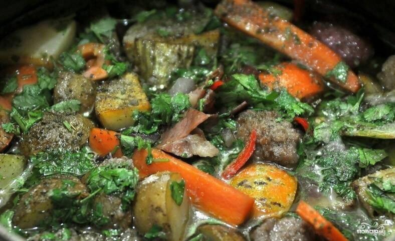 На мясо выложите лук, морковку, сельдерей, помидоры, перец острый и все остальные овощи. Потом картошку посолите и поперчите, добавьте специи по вкусу. Сверху выложите кусочки бекона. Теперь смешайте бульон с вином, доведите до кипения. Смесь вылейте в чугунок. Ее должно хватить, чтобы покрыть полностью мясо и картошку. Вот такой "набитый" у меня чугунок получился. 
Отправьте его в разогретую до 250 градусов духовку с плотно закрытой крышкой на часа два. 