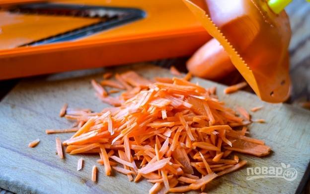 Морковь помойте, почистите и натрите её на тёрке для корейской морковки или подобной.