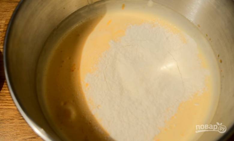 4. К взбитым яйцам порционно добавьте ранее приготовленную мучную смесь, каждый раз вмешивайте ее лопаткой. 