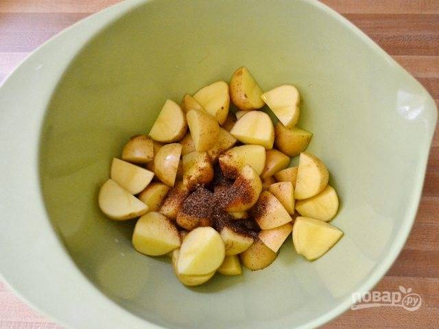 1.	Вымойте картофель и обсушите салфетками. Нарежьте картофель небольшими кусочками. Выложите овощи в миску и добавьте все специи с солью, а также оливковое масло, перемешайте.