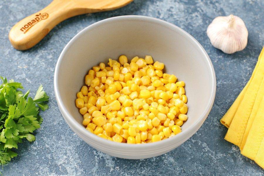 С кукурузы слейте жидкость и переложите её в глубокую миску или сразу в салатник.