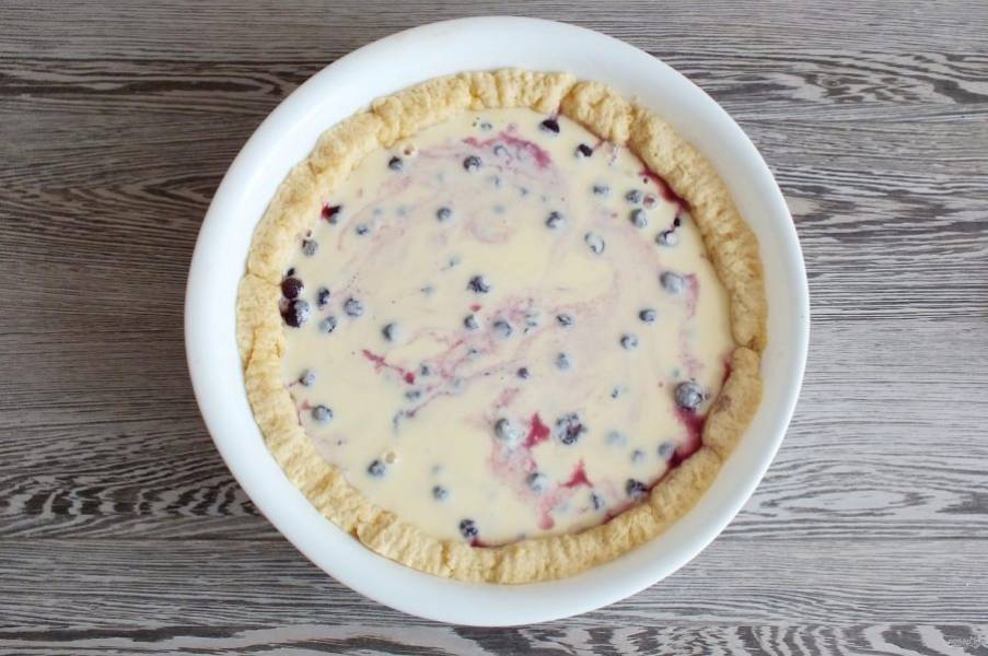 На ягоду вылейте заливку. Распределите. Поставьте выпекаться пирог в разогретую до 180 градусов духовку на 35 минут. Учитывайте особенности своей духовки.