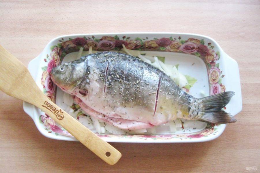 Посыпьте приправой для рыбы. Отправьте карпа в духовку, разогретую до 180 градусов.