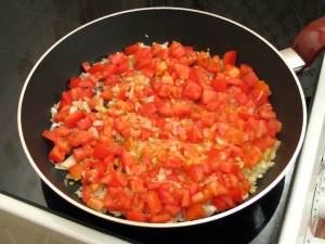 Добавляем в сковородку помидоры. Жарим их 2-3 минуты.