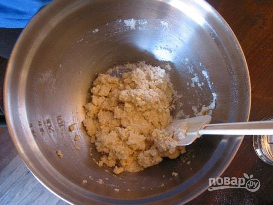 3. Переложите ее в мисочку и по одной ложке добавляйте ледяную воду, постоянно перемешивая. Должно получиться однородное, мягкое тесто. Работать нужно быстро, чтобы масло не таяло. 