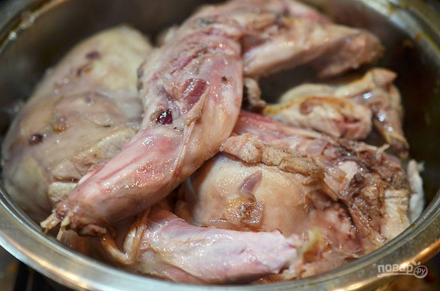 Добавьте к луку мясо кролика и обжаривайте по 3 минуты с каждой стороны.