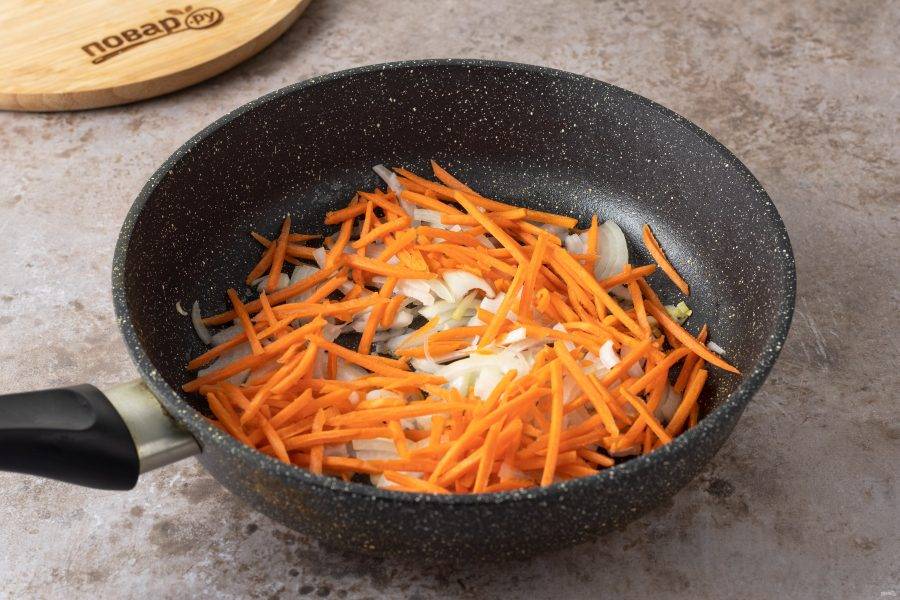 Морковь очистите и натрите на тёрке, репчатый лук нарежьте полукольцами. Обжарьте на среднем огне с растительным маслом 5 минут.