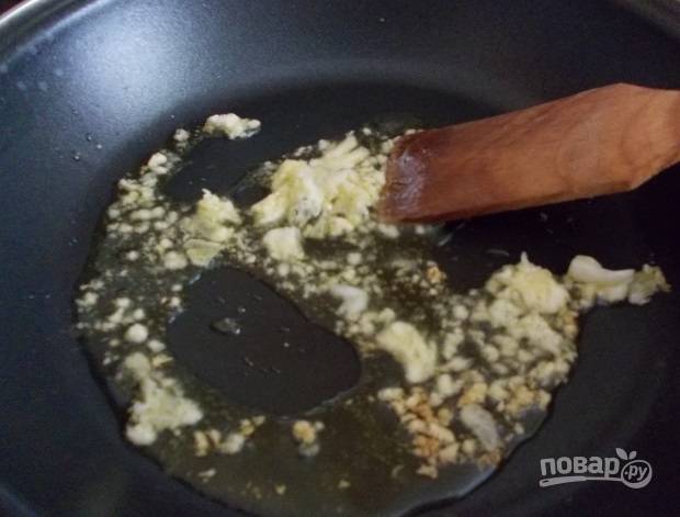 Поставьте сковороду на плиту и разогрейте ее. Распустите на ней кусочек сливочного масла. Очистите зубчики чеснока, измельчите их ножом или пропустите через пресс. Обжарьте чеснок на сливочном масле. 