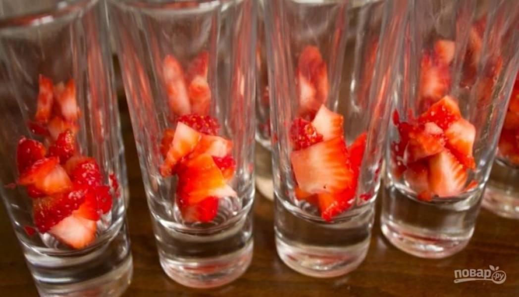 3.	Возьмите шоты или высокие стопки, на дно выложите ягоды клубники.