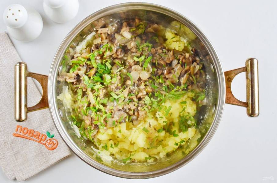 С готового картофеля слейте всю воду, толкушкой превратите в пюре, добавьте грибы с луком вместе с жиром, на котором они жарились. Добавьте зелень и перемешайте, откорректируйте на соль.