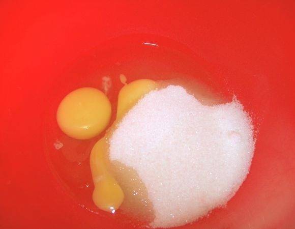 1. Первым делом следует приготовить бисквит. Соедините в глубокой мисочке яйца с сахаром. При желании вы можете следовать классическому варианту, когда желтки взбиваются отдельно от белков. 