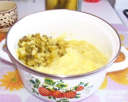 Отварите и растолките картофель, добавьте в пюре масло и мелко нарезанные солёные огурцы.