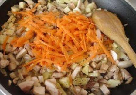 Морковь чистим, моем и натираем на терке. Отправляем на сковороду к грибам. Солим, перчим и тушим 10-15 минут.